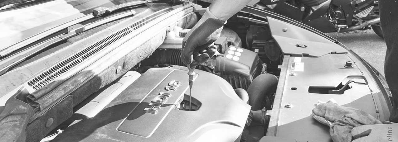mechanic checking oil on car grayscale
