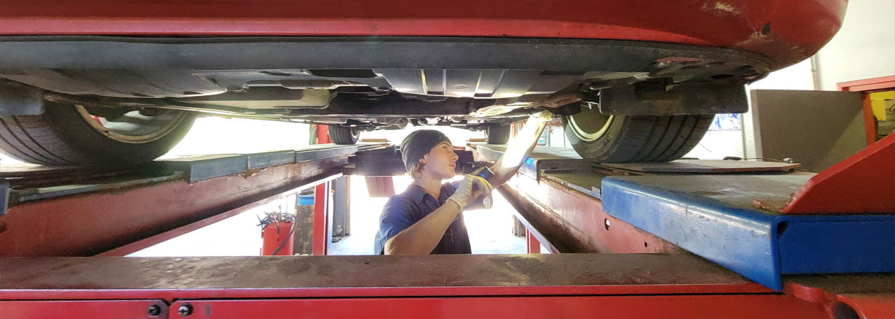 A High Country Diesel mechanic inspecting under a vehicle during routine service